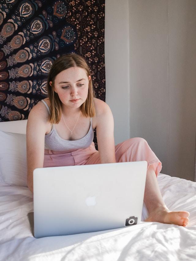 Picture of teenage girl in bedroom with laptop